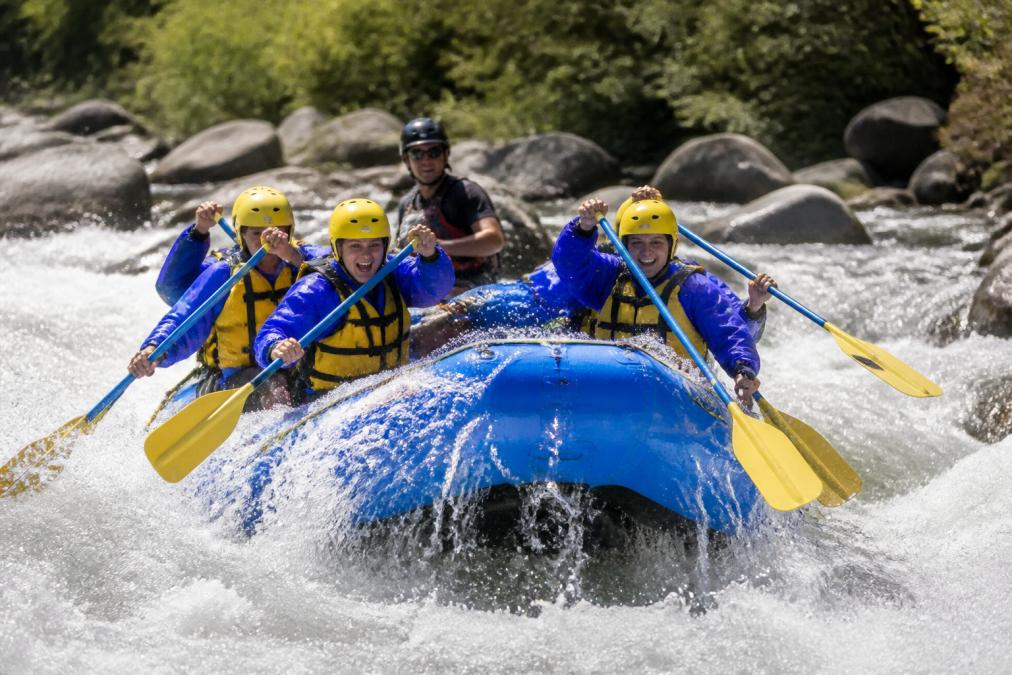 Infographic showing muscles worked during guided rafting through Class III rapids on a sunny river day.