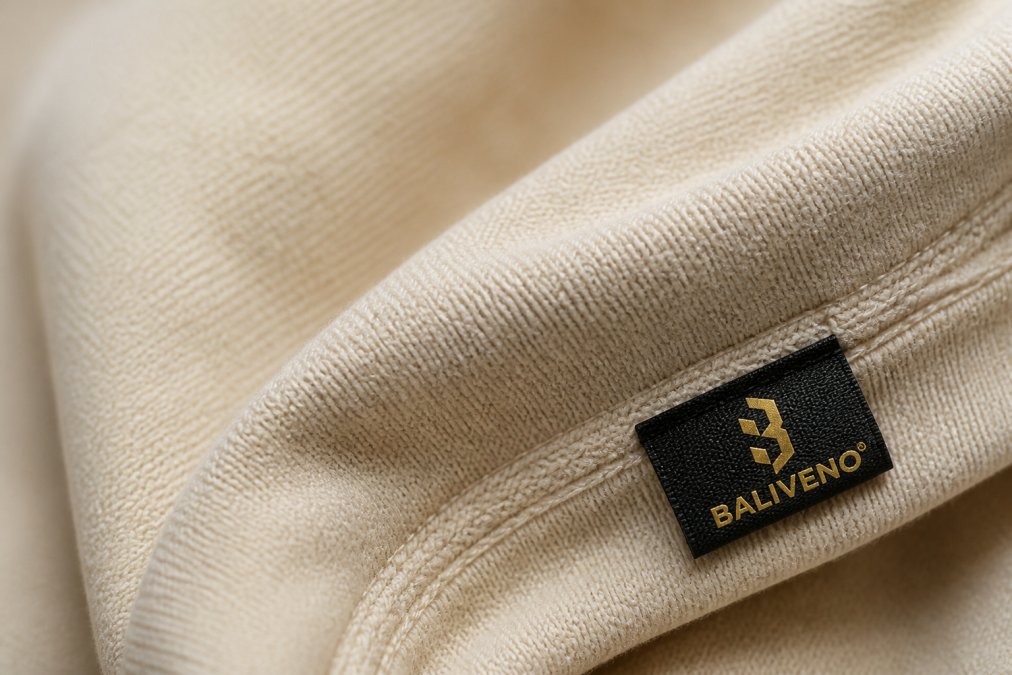 Close-up of high-quality organic cotton fabric texture showing tight weave and detailed stitching, with natural lighting revealing the craftsmanship and material density