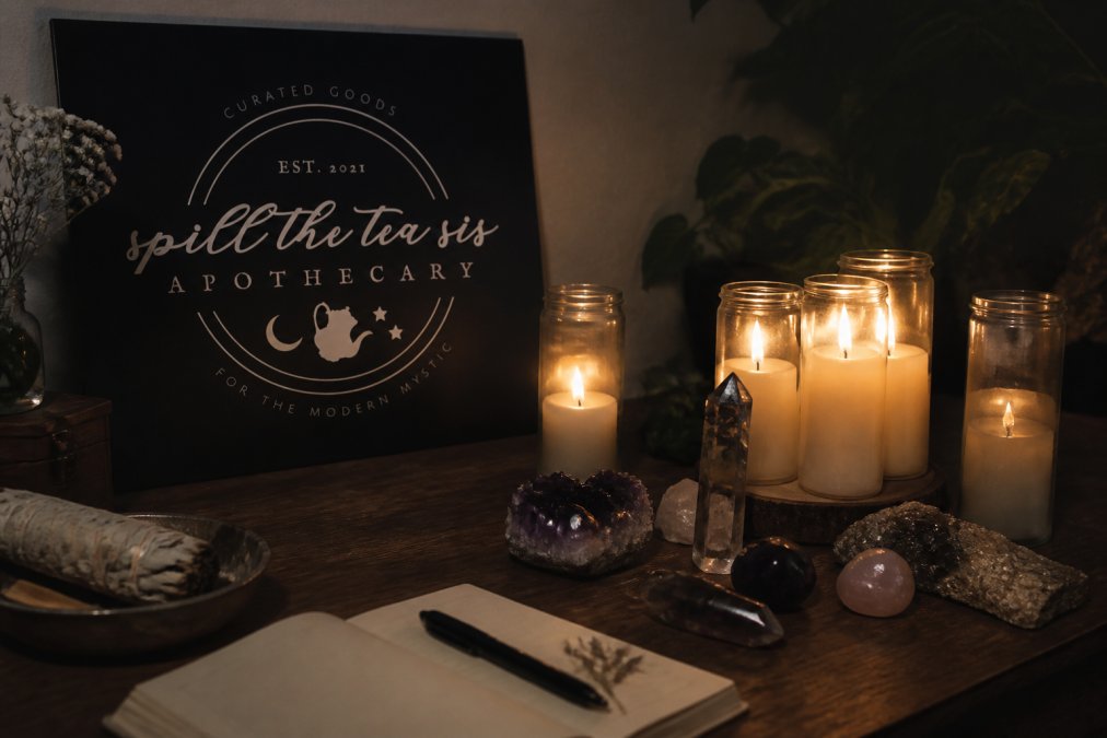 A serene sacred space with lit intention candles arranged on a wooden surface, crystals placed intentionally nearby, soft candlelight creating warm shadows, and a peaceful, contemplative atmosphere perfect for spiritual ritual work