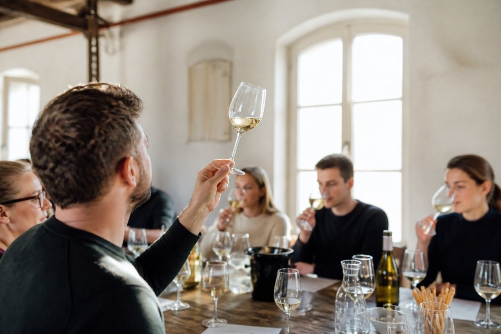 Weinliebhaber bei der sensorischen Analyse, um die Besonderheiten rheinhessischer Weine zu verstehen.