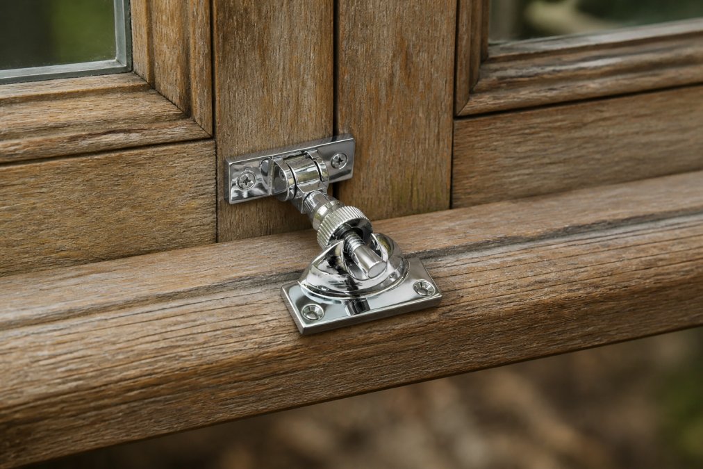 Close-up of a timber window frame showing detailed grain patterns, weather-worn surfaces, and visible joinery joints where wood sections meet, photographed in natural daylight from an older property