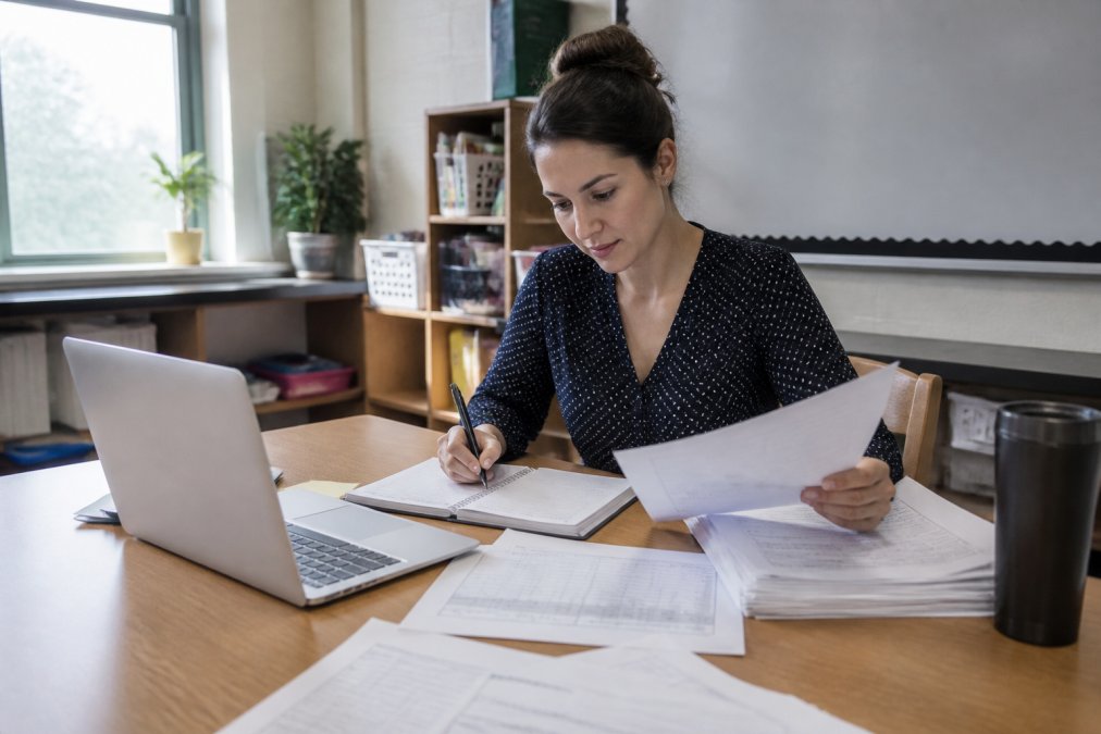 Teacher reviewing lesson materials and worksheets to refine the best ai prompts for creating lesson plans.