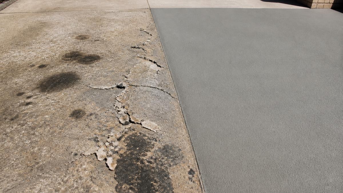Weathered driveway with peeling sealer and cracks beside smooth concrete sealing results