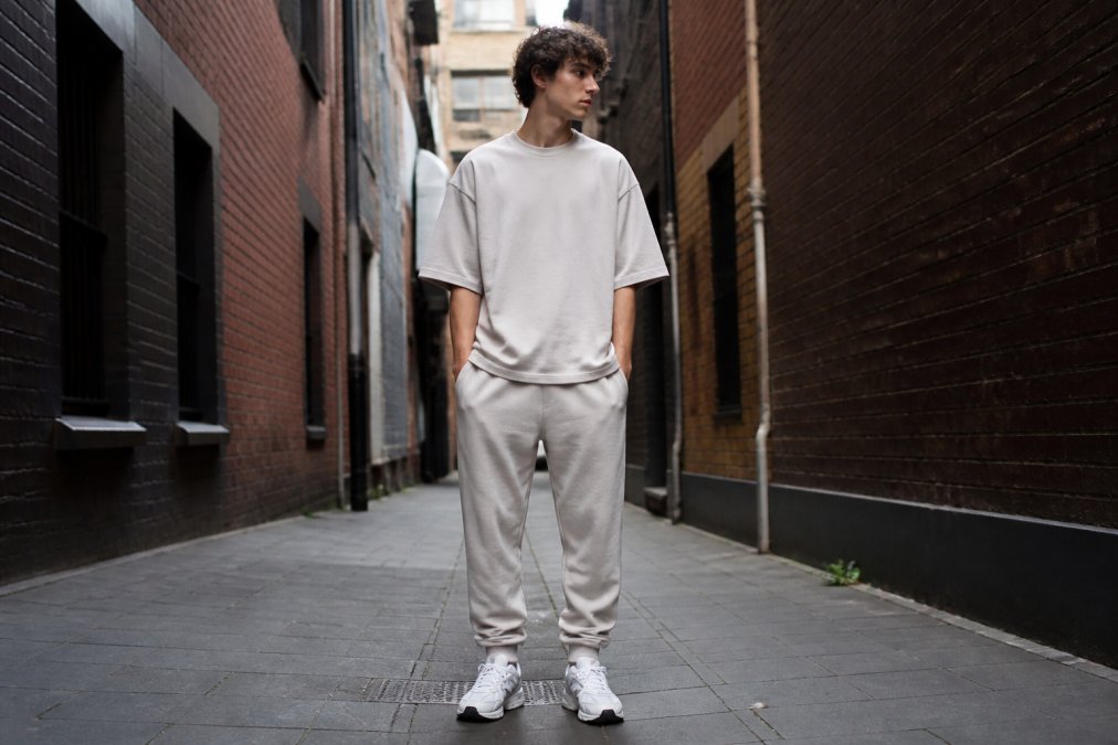 Young person wearing oversized BLNCE heavyweight tee and joggers in urban laneway setting with natural daylight, showcasing relaxed fit and clean aesthetic of Australian made streetwear