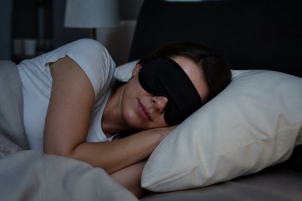 Diagram demonstrating the proper fit of a contoured sleep mask against a pillow while lying on one's side