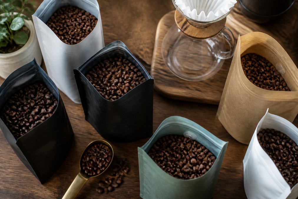 Freshly roasted coffee bags and a pour-over setup for blue bottle alternatives in warm natural light.