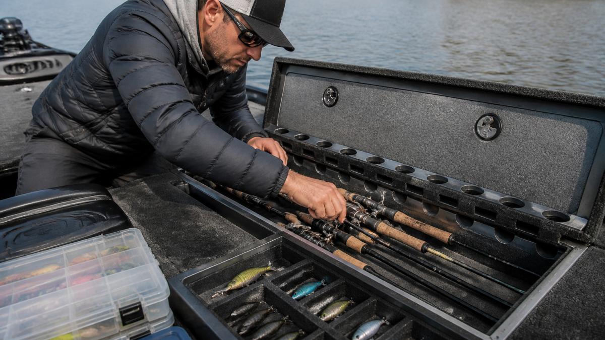 Tournament angler organizing gear in custom bass boat storage compartments, representing the best boat storage for