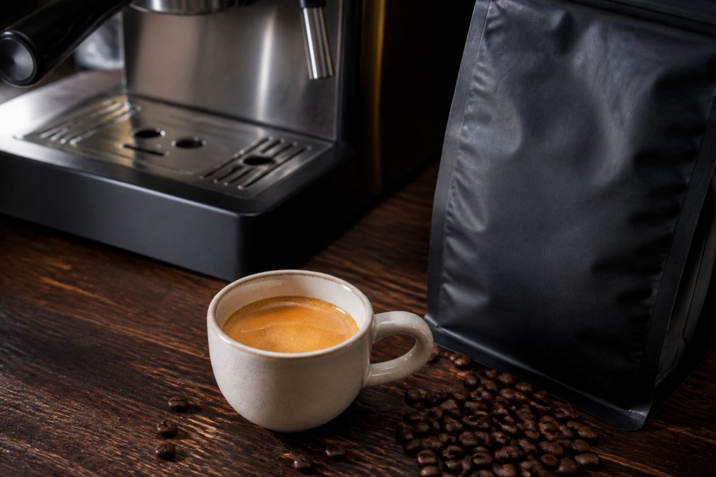 Freshly pulled double espresso with thick crema next to a bag of beans, perfect for the best coffee subscription for