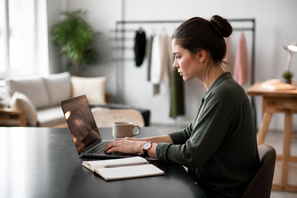 Marketing manager analysing campaign data for authentic creators on a laptop in a modern studio office.