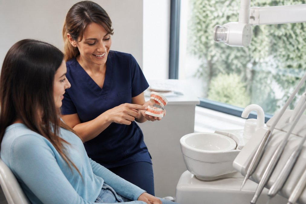 A friendly dentist reviews a treatment plan on a tablet with a patient at the best dental clinic in Toronto 2026.