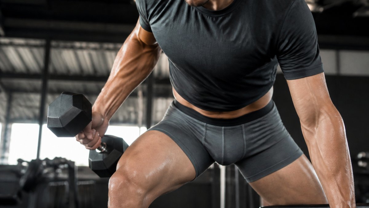 Close-up of a man wearing ergonomic boxer briefs during an intense gym session, showing comfort and proper fit during movement