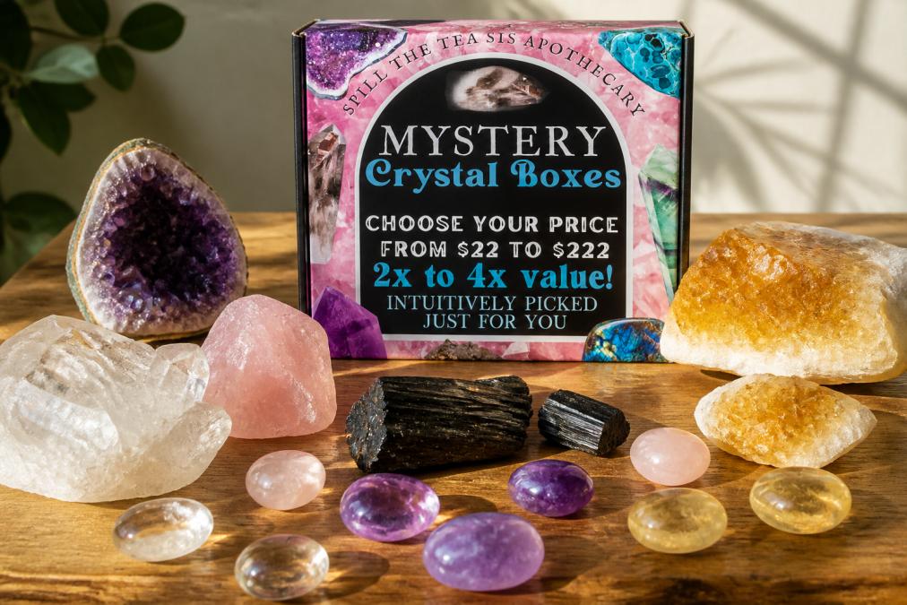 A collection of raw and polished crystals arranged on a natural wooden surface with soft morning sunlight, displaying amethyst, clear quartz, rose quartz, black tourmaline, and citrine in various sizes and finishes