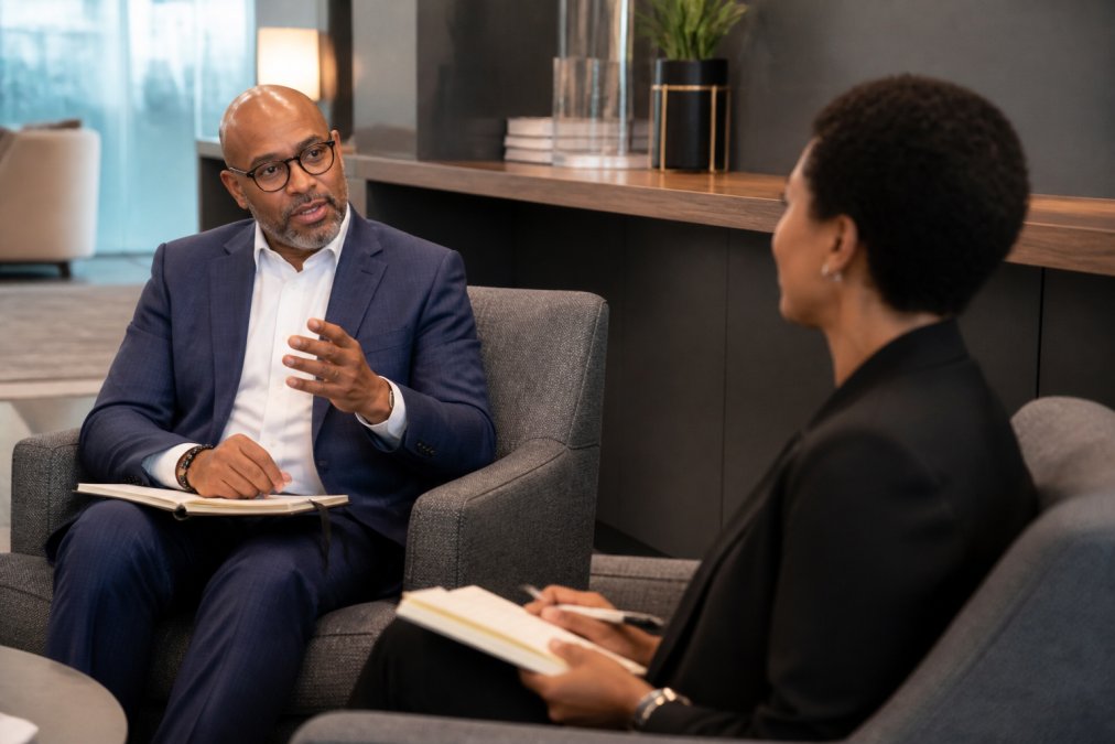 Confident executive and leadership coach in a modern office during an executive coaching session.