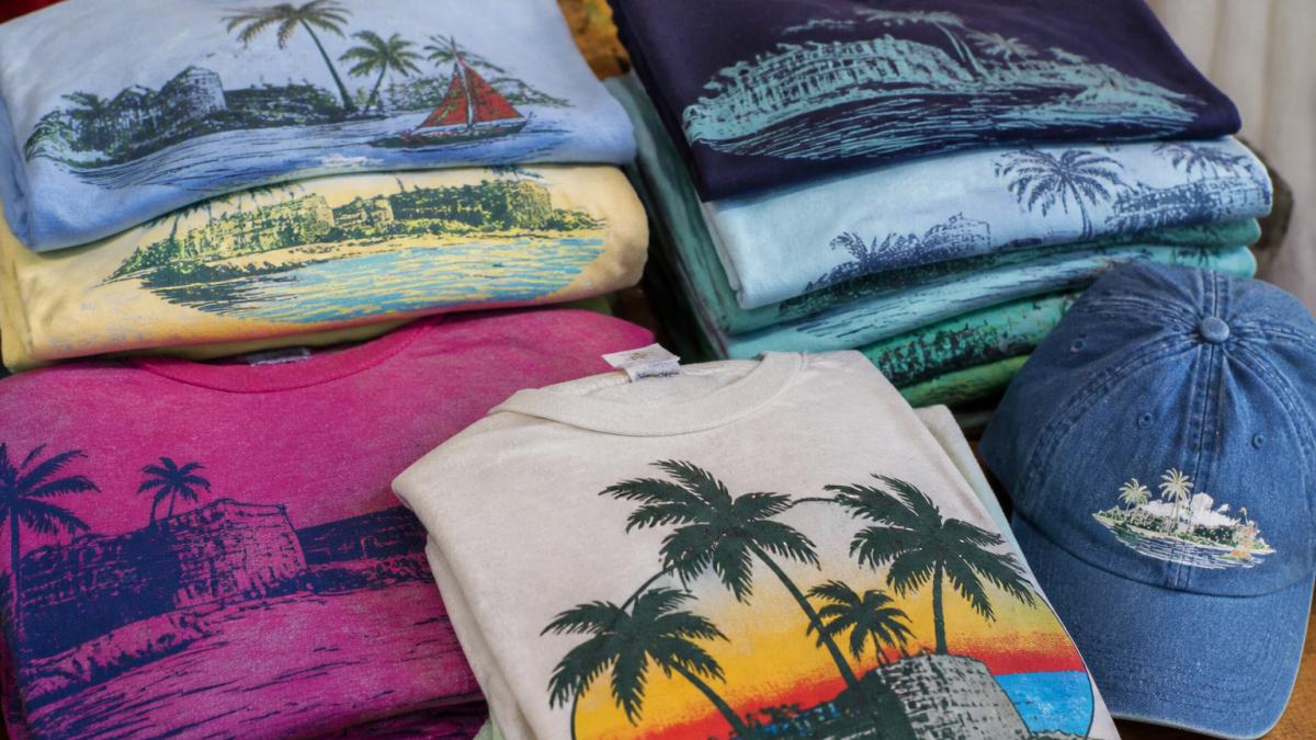Close-up of vintage St. Croix apparel and trademarked tees displayed together, showing authentic local artwork and nostalgic island logos in natural daylight