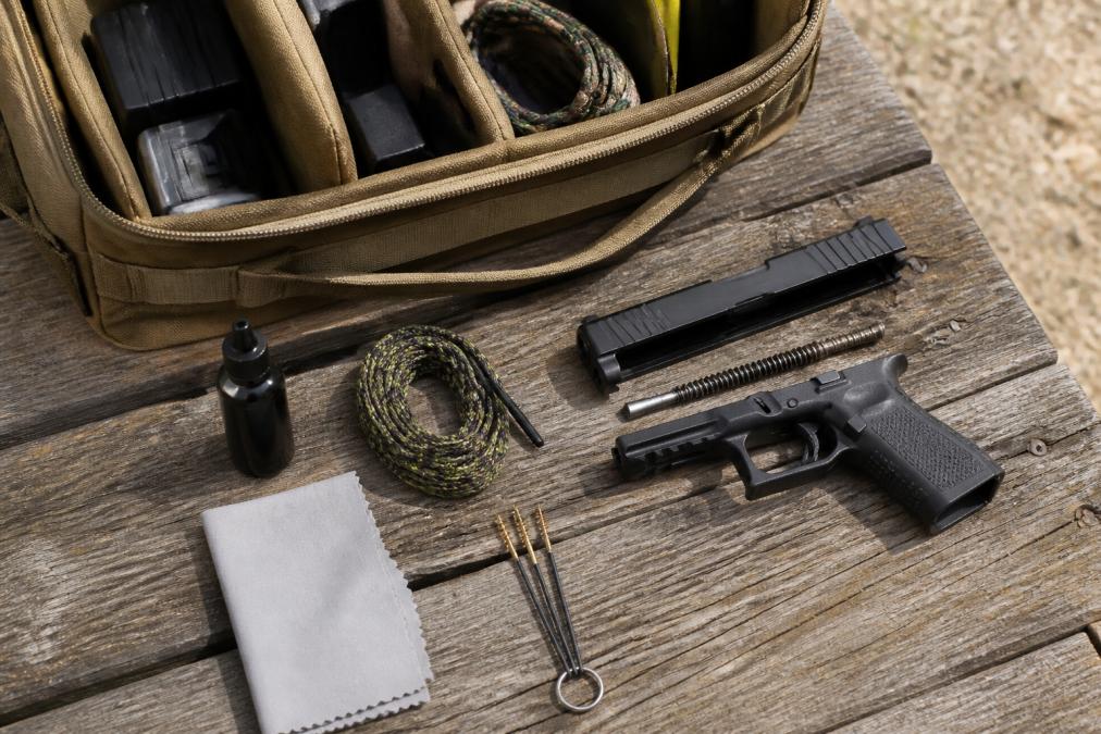 Diagram showing essential gun cleaner tools and supplies organized for field maintenance of a disassembled pistol