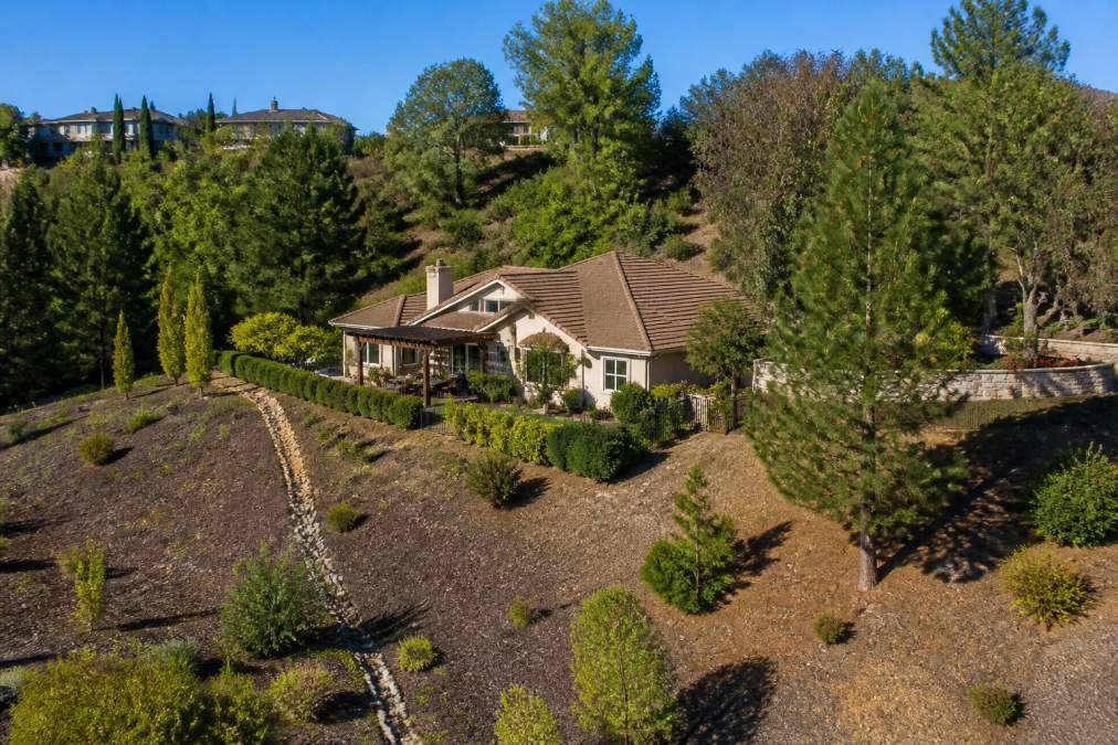 Suburban home surrounded by cleared landscaping and vegetation management, demonstrating wildfire mitigation measures and property maintenance