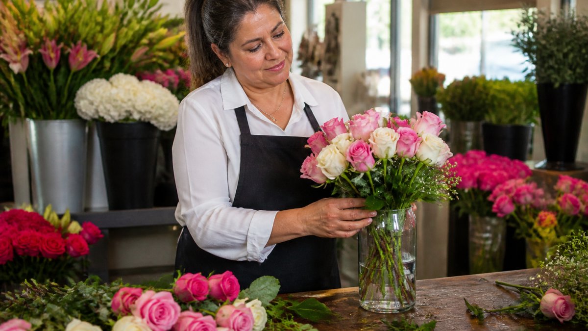 Florist arranging pink and white roses as one of many local florist alternatives for fresh bouquets.