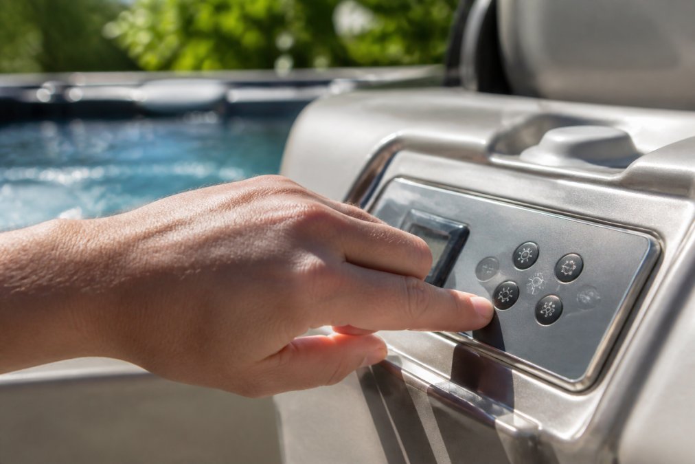 Close-up of digital control panel on modern hot tub displaying water chemistry readings including pH, alkalinity, and sanitizer levels with automated system status indicators