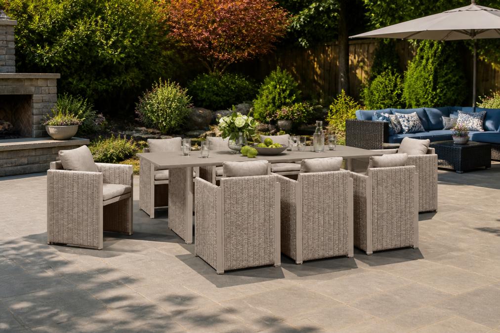Well-maintained outdoor patio with various furniture materials visible, aluminum chairs, wicker seating, and cushioned pieces arranged in a relaxing garden setting with minimal visible wear and vibrant plants