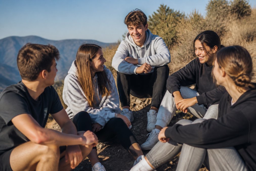 Young adults and teenagers wearing faith-inspired casual apparel in everyday settings, displaying comfortable fit and modern design with natural outdoor lighting