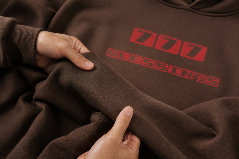 Close-up of premium vintage-washed cotton fabric texture showing soft weave and natural color variations, with hands gently touching the material to demonstrate quality and comfort of minimalist spiritual apparel