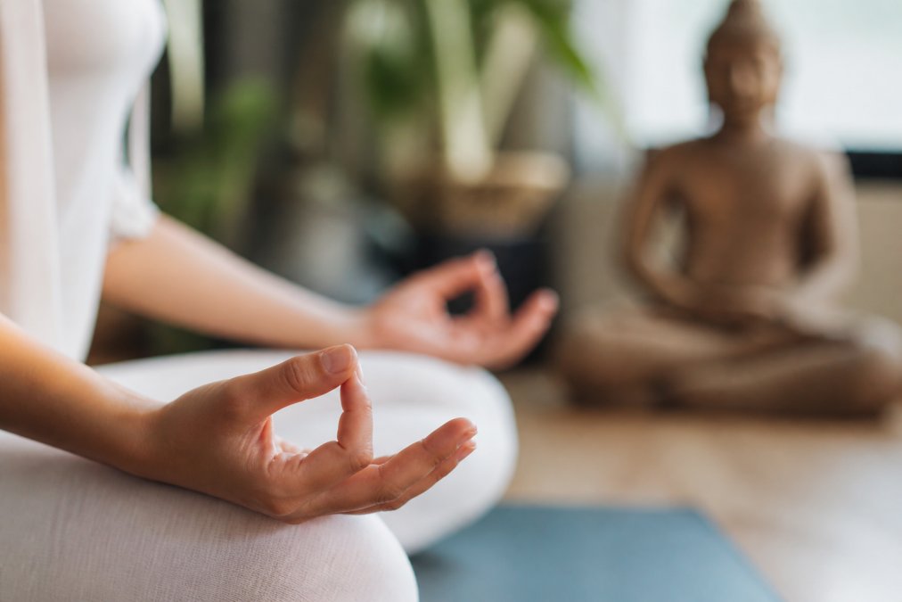 Hands resting in Gyan Mudra on knees, one of the best mudras for reducing anxiety and stress in a calm room.