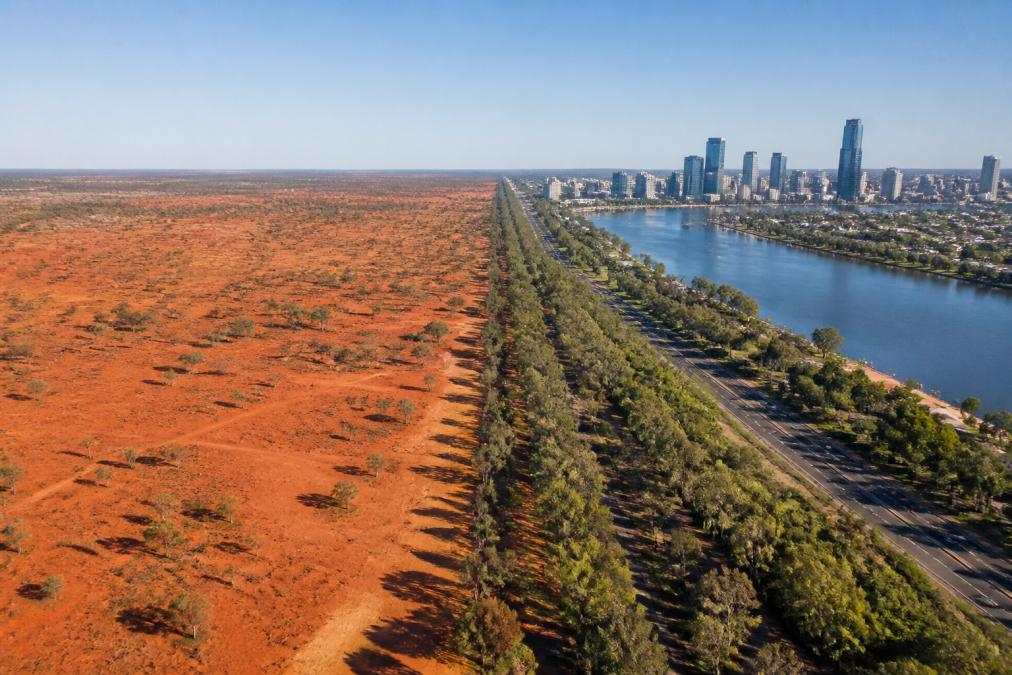 A split image showing the stark red dirt of the outback on one side and the glass towers of a city skyline on the other, divided by a thin line of bushland