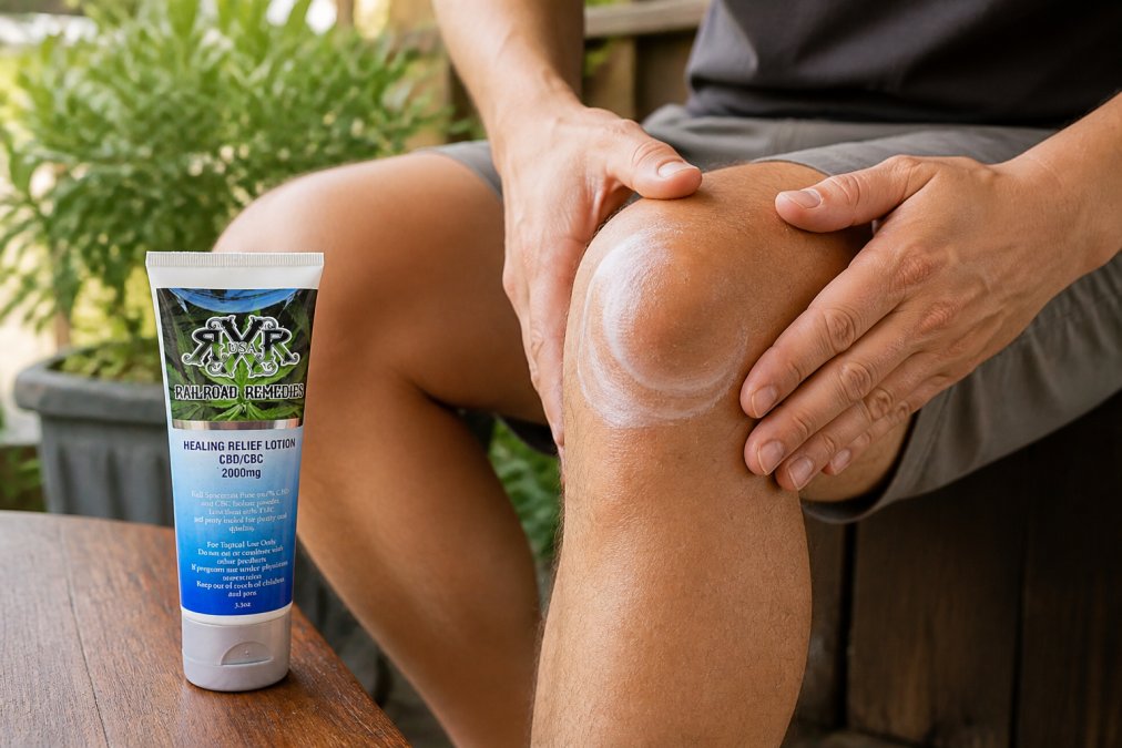 Close-up of hands applying CBD salve with gentle circular massage motions to knee joint on a person seated in natural sunlight