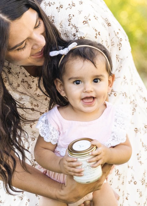 Baby Holding Jar of Tallow Baby Balm