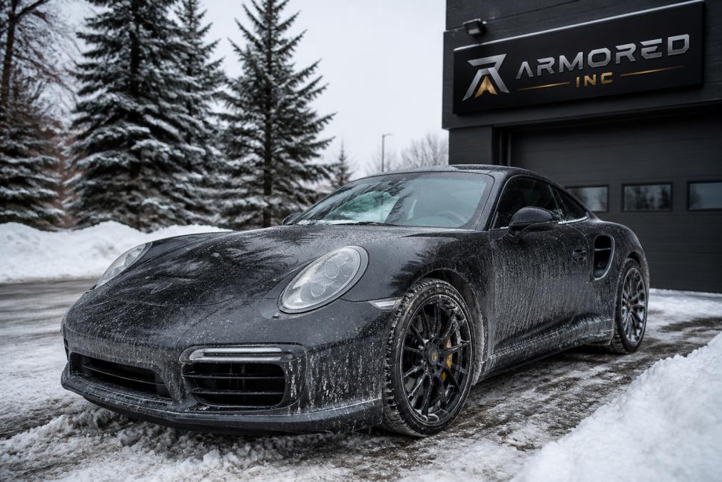 A sports car parked in a winter environment with visible salt residue and snow on the ground, demonstrating the harsh environmental conditions that paint protection guards against
