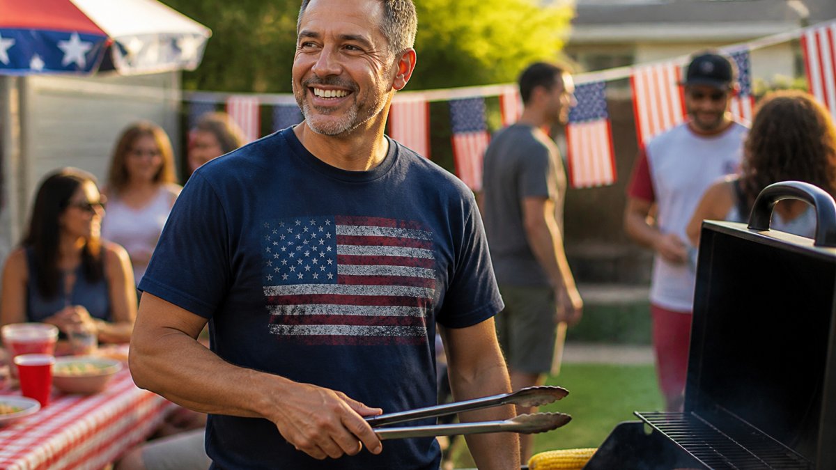 Smiling man wearing a graphic patriotic t-shirt at a sunny summer barbecue outdoors