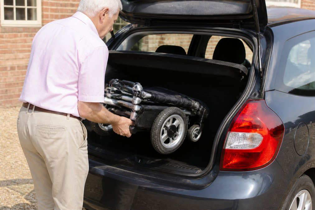 Diagram demonstrating how a portable mobility scooter folds into a car boot for easy transport