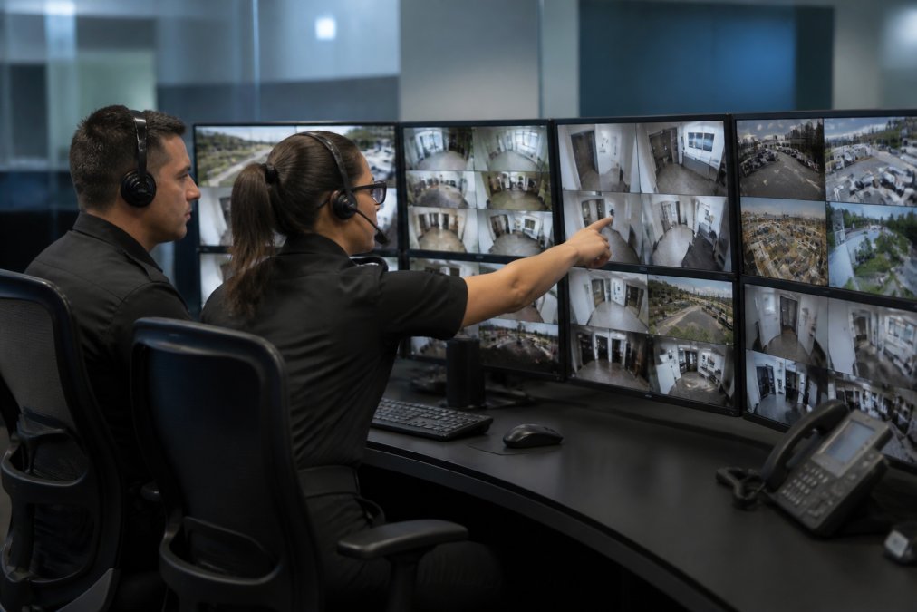 Security analysts coordinating incident response via central security management systems in a live monitoring center
