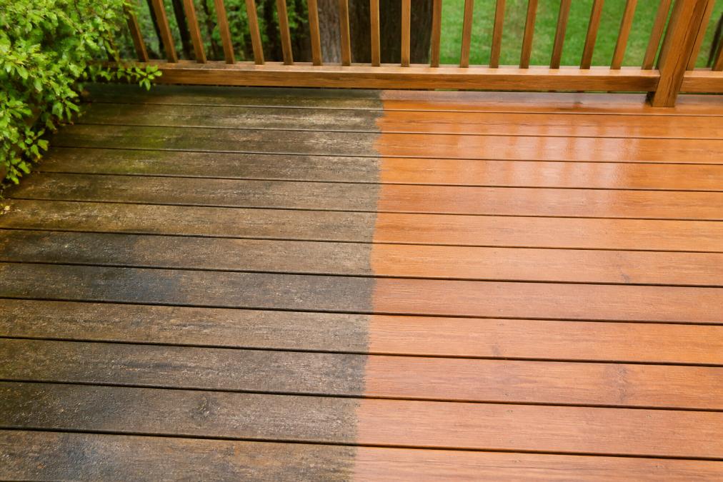Before-and-after comparison showing a deck section with visible dirt, stains, and weathering on one side, and pristine clean, bright surface on the other side