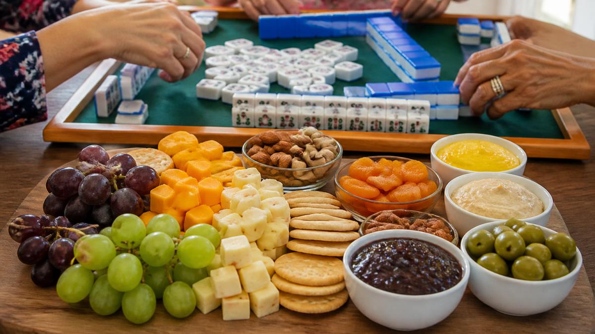 Infographic showing a step-by-step arrangement guide for a colorful snack board next to a game in progress