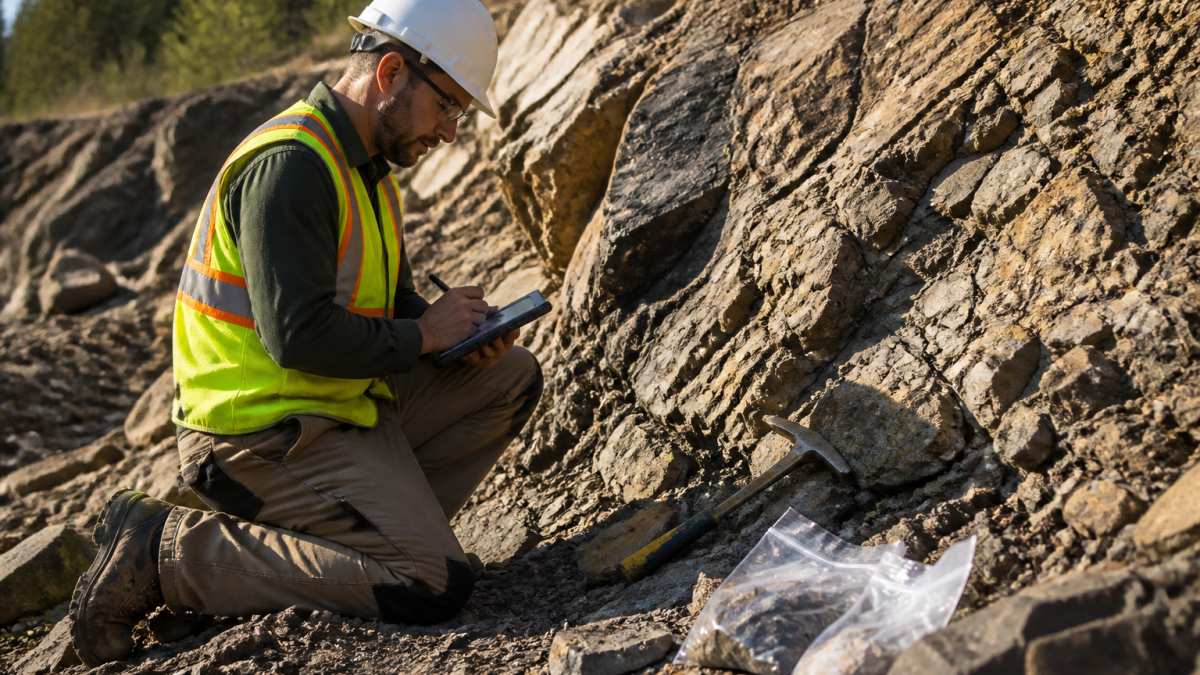 Geologist recording data on a rugged tablet at remote exploration sites