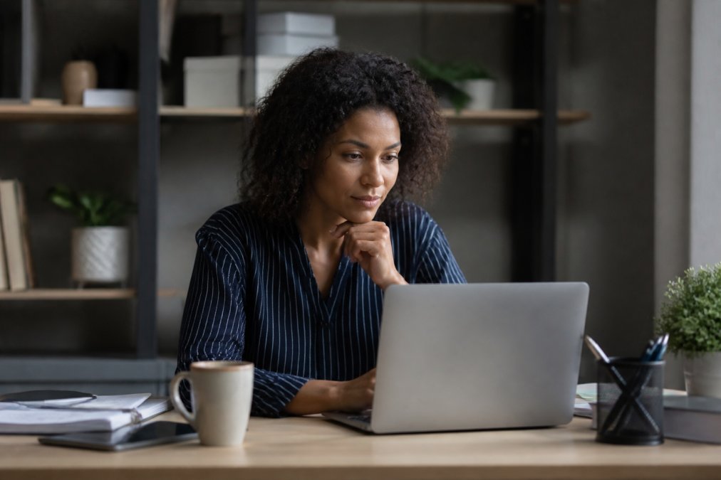 Professional sitting at a desk writing the best subject lines for interview thank you emails on a laptop