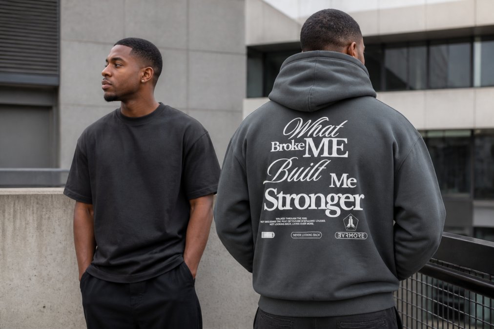 Man wearing premium heavyweight EVRMORE hoodie and tee in Slate and Black colorways, posed confidently in urban setting with natural daylight, demonstrating how sustainable streetwear brands fit into everyday style