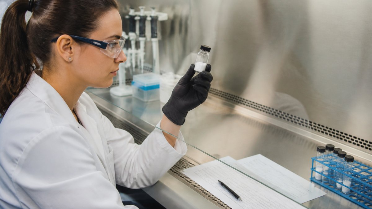 Researcher examining a vial of peptide powder while vetting the best tirzepatide research grade suppliers