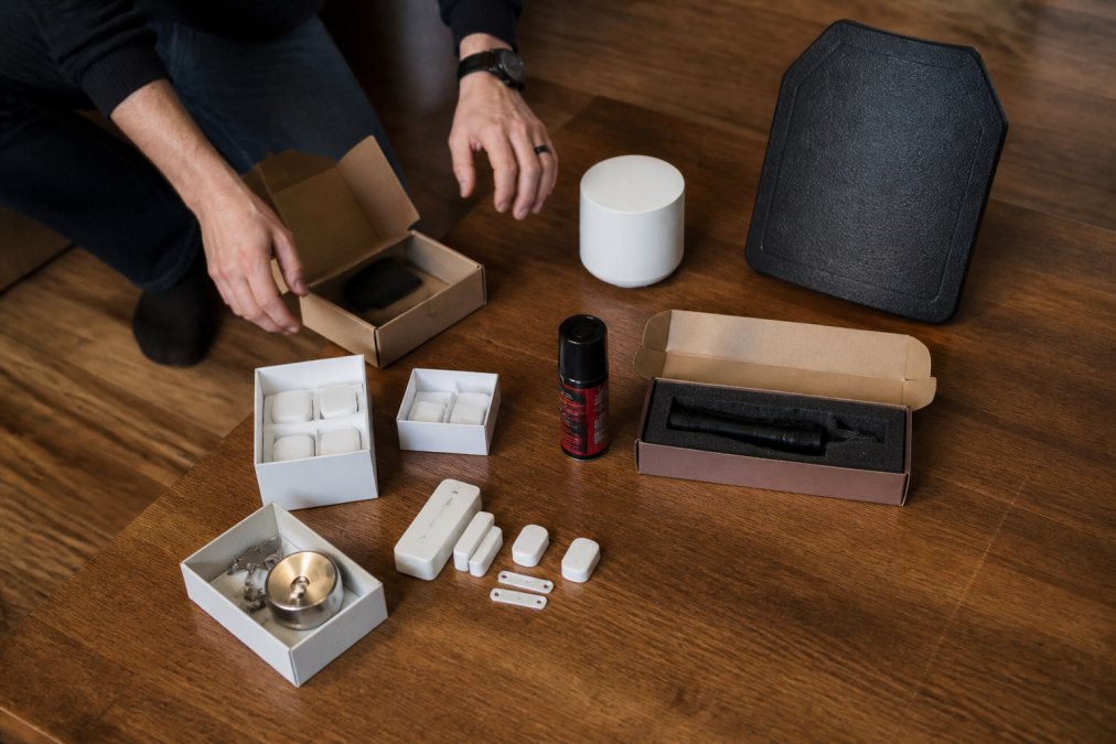 Overhead view of best value tactical accessories for home defense arranged by price tiers on a table surface.