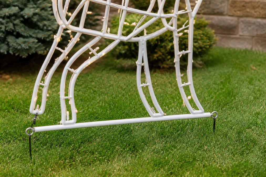 Close-up of properly installed powder-coated metal holiday light sculpture with visible protective coating and galvanized base, secured to residential lawn with ground anchors visible