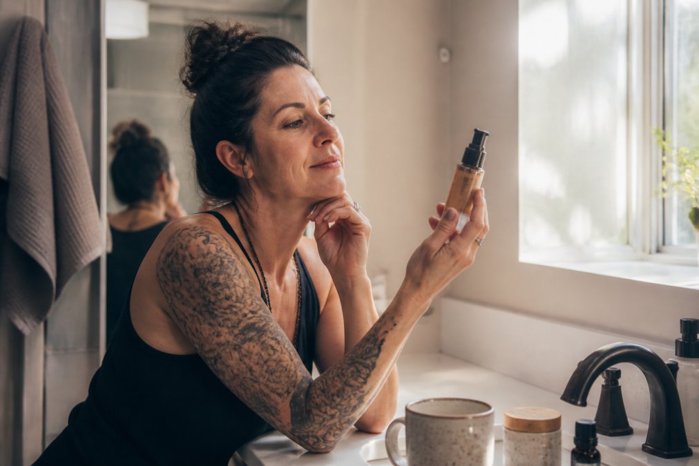 Woman in her forties applying skincare as one of the best wellness products for perimenopause in a morning routine.