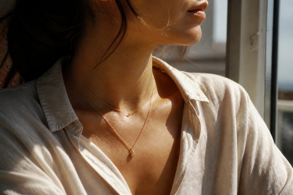 Femme portant deux colliers fins en superposition pour un style de bijoux minimalistes élégant et raffiné.