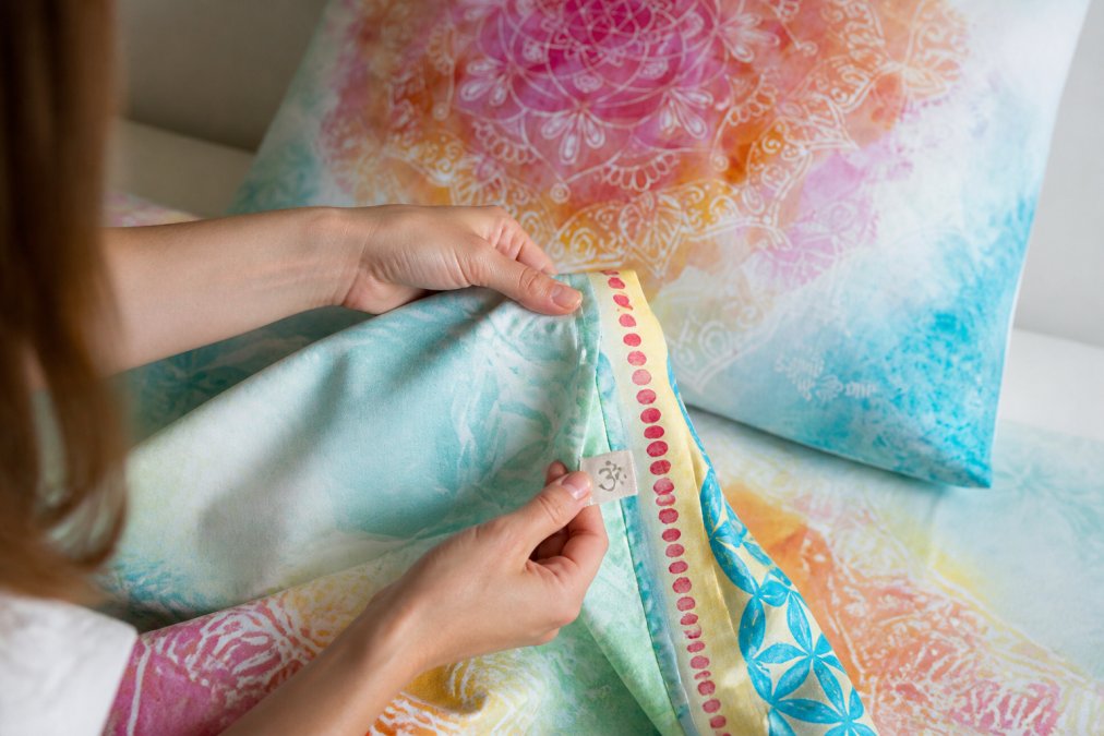 Detailní pohled na ruce zkoumající bio bavlnu s certifikací pro článek Bio móda a bytový textil – jak poznat kvalitu.