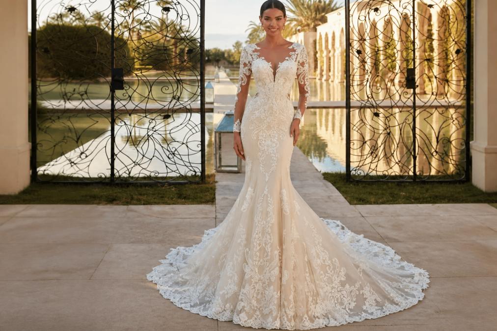 Bride in flowing boho mermaid wedding dress with delicate lace sleeves and dramatic train, showcasing graceful silhouette with movement and draping against soft natural lighting