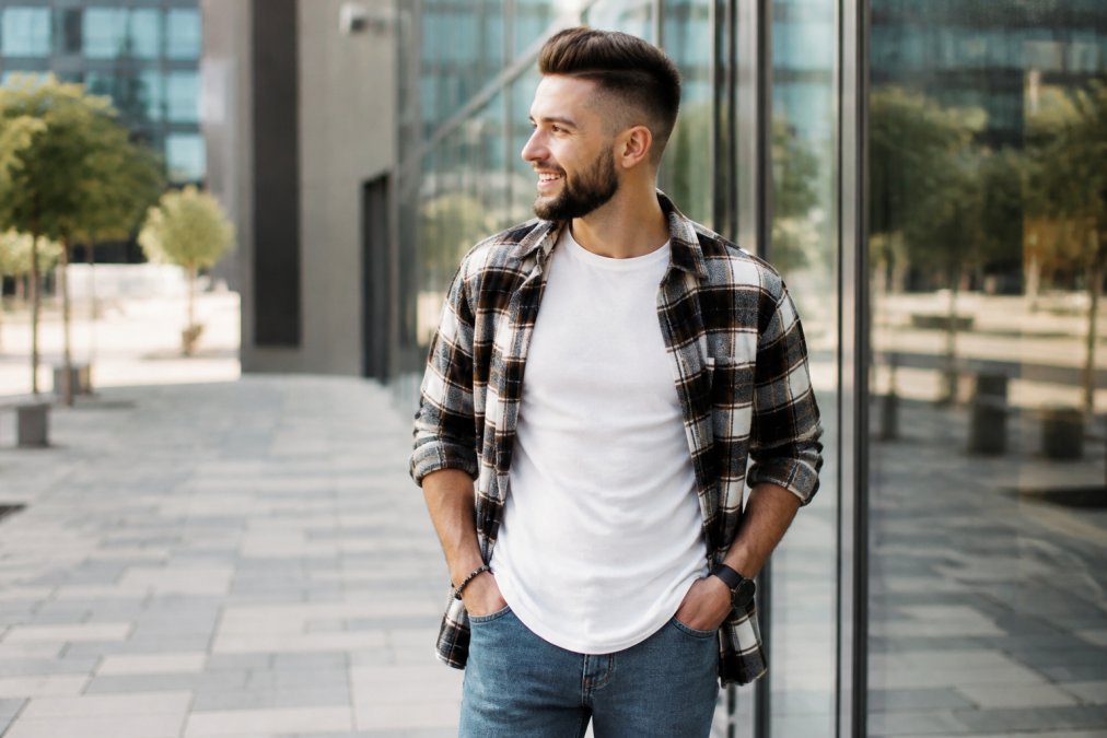 Man wearing a graphic tee and flannel in an urban setting featuring bold christian apparel for a casual look