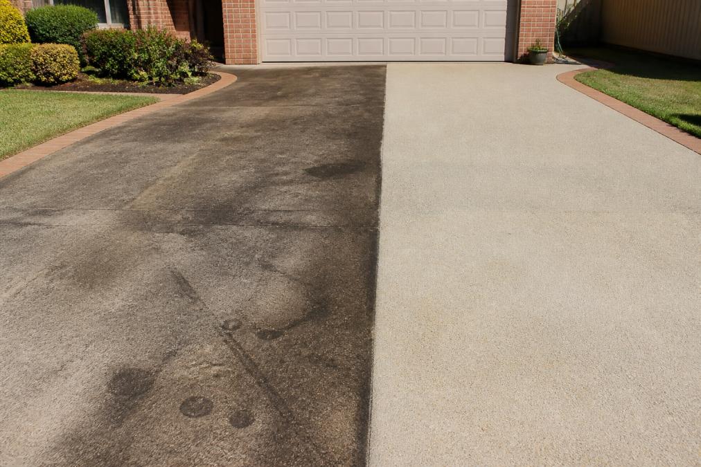 Before-and-after scene of a driveway restoration showing heavily stained concrete with visible oil marks and dirt, transitioning to the same driveway freshly cleaned and bright, with dramatic contrast