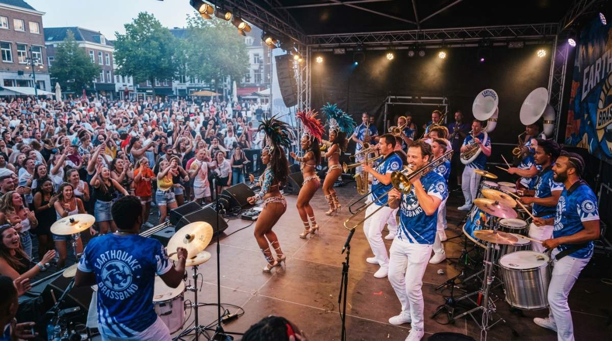 Brassband-leden in volledige uitvoering met samba-dansers en percussionisten op een groot buitenpodium tijdens een feestelijk evenement, met publiek dat meezingt en danst
