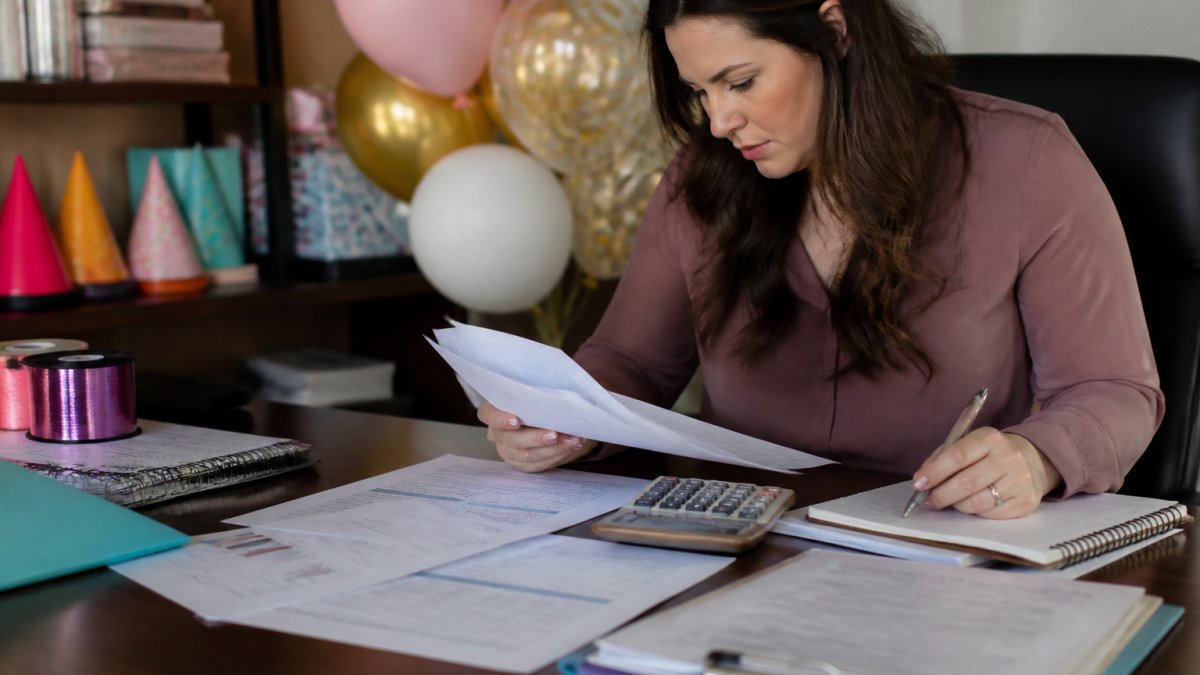 Event planner reviewing spreadsheets and vendor quotes when budgeting for large scale event supplies at a desk