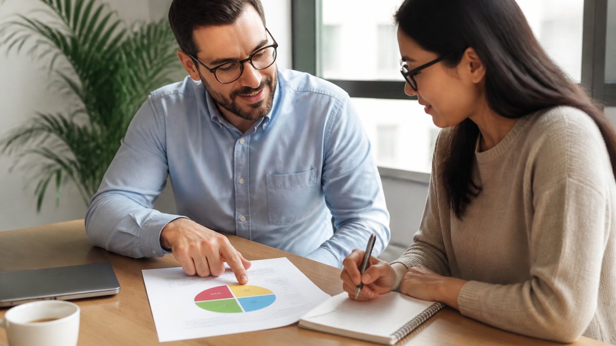 Two colleagues reviewing a DiSC behavioral profile chart while building professional rapport in an office setting.
